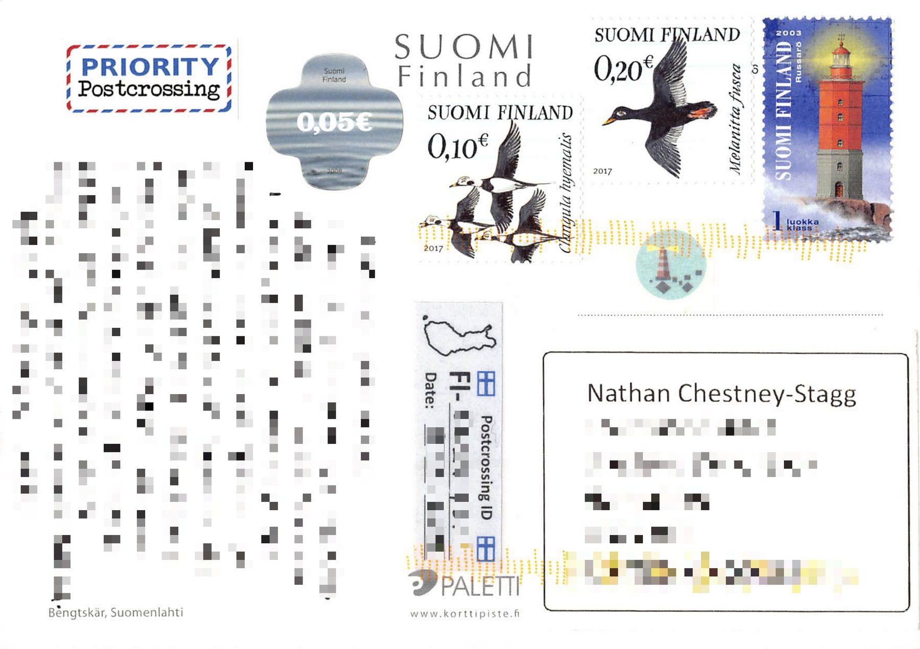 Postcard back: Finnish stamps including the 2003 Russarö lighthouse stamp, a small lighthouse sticker and a Postcrossing label, with the message and address blurred